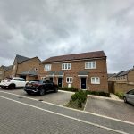Modern brick houses with parked cars in driveway.